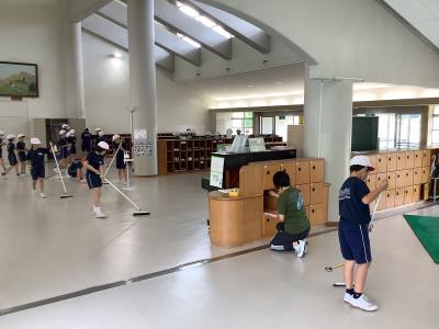 下駄箱周辺を掃き掃除する児童
