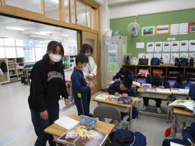 教室の入り口から授業の様子を見ル保護者