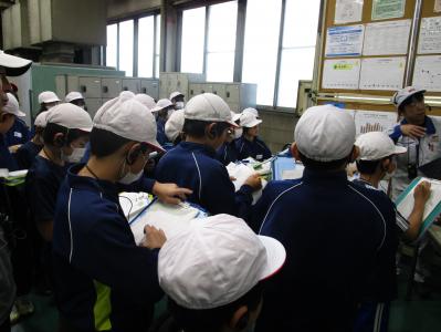 社員の話を聞いてメモをとる児童