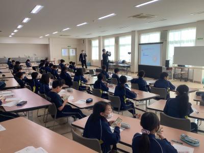 お金の数え方を説明する行員