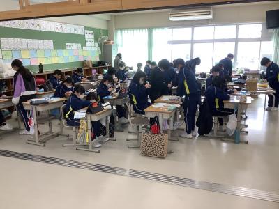 お手本の動画を見ながら裁縫をする6年生