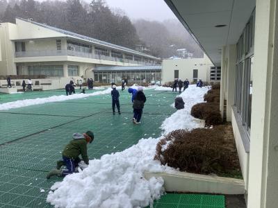 中庭で雪遊びする児童