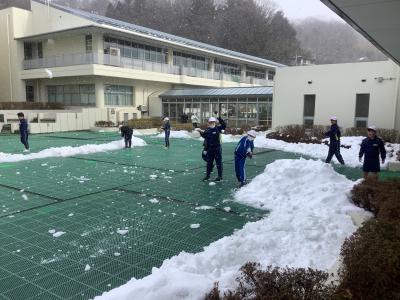 中庭で雪遊びする児童