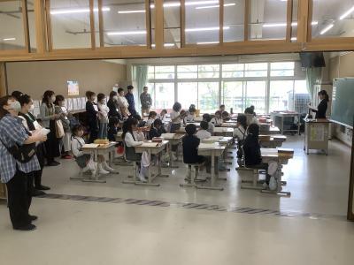 3年生の教室を右側から撮った写真です。教師が板書していて保護者が教室の後方から参観しています。