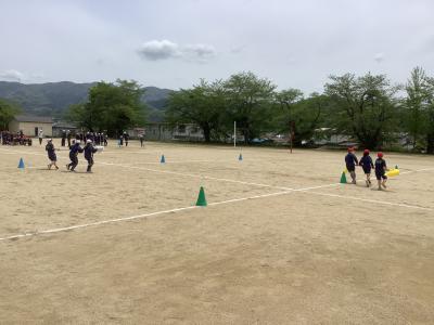 棒を持ってコーンを回る4年生