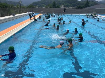 5年生に手を引かれながらバタ足の練習をする2年生