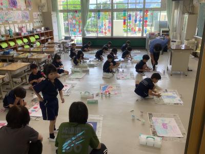 指で絵の具をのばす活動をする1年生