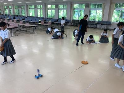 風を受けて走る車の移動距離をはかる3年生