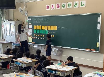 黒板を使って枚数の違いを示す1年生