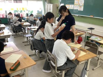 パッケージの栄養表示を先生と見る4年生
