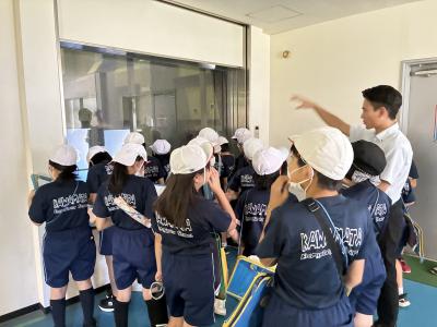 ゴミ処理場をのぞき込む児童