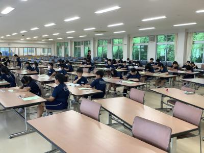 宿泊学習のしおりに記入する5年生