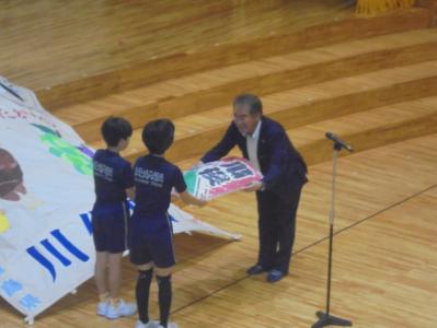凧を譲渡する社長と受け取る児童