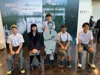 野口英世のポップと一緒に写真を撮る6年生