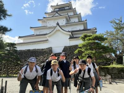 鶴ヶ城と記念撮影する6年生